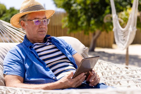 Blanke Senior Man Draagt Een Hoed Met Digitale Tablet Terwijl — Stockfoto