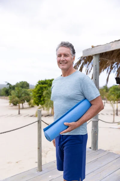 Retrato Homem Sênior Caucasiano Sorridente Com Tapete Exercício Azul Resort — Fotografia de Stock