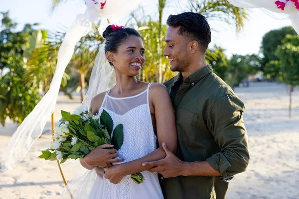 白种人新婚夫妇笑着在海滩举行的婚礼上互相望着对方 不变的 在一起 目的地婚礼 — 图库照片