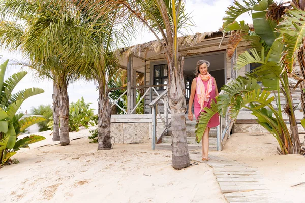 Biała Starsza Kobieta Spacerująca Promenadzie Wśród Palm Piaszczystej Plaży Przeciwko — Zdjęcie stockowe