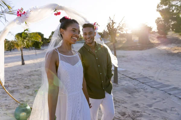 在夕阳西下的婚礼上 一对白种人新婚夫妇站在海滩上迎风微笑 复制空间 在一起 目的地婚礼 — 图库照片