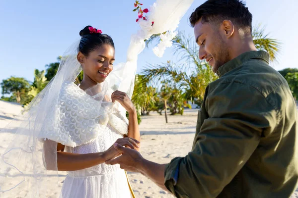 在海滩上举行的婚礼上 白种人年轻的新郎戴着结婚戒指与美丽的新娘在一起 不变的 在一起 目的地婚礼 夏天的概念 — 图库照片