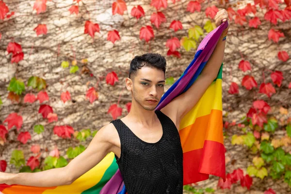 以背景为岩石和树叶的 手持彩虹旗的鸟类变性人的肖像 Gender Lgbtq Pride Lifestyle Unchanged — 图库照片