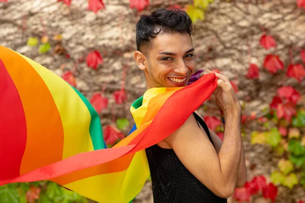 岩や葉を背景に 虹の旗を持つ幸せな出生トランスジェンダーの男の肖像画 Lgbtq 誇りと生活様式 変更なし — ストック写真