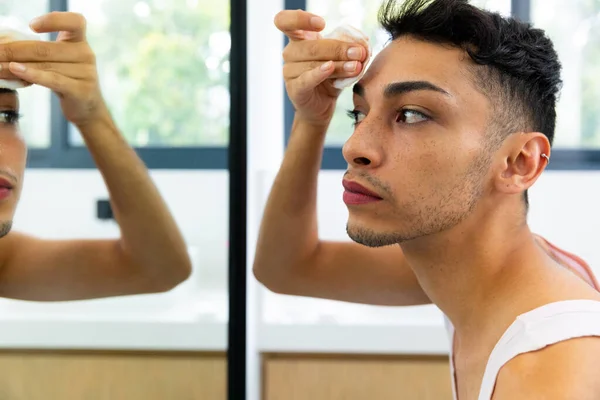 Biracial Transgender Man Tittar Spegeln Med Hjälp Bomullspad För Rengöring — Stockfoto