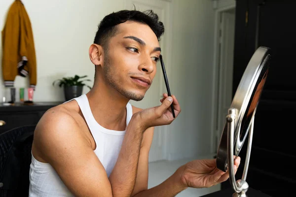 出生のトランスジェンダーの男性は 鏡を見て メイクをし アイシャドウを適用します セルフケア 美しさ ライフスタイルと国内生活 変更なし — ストック写真