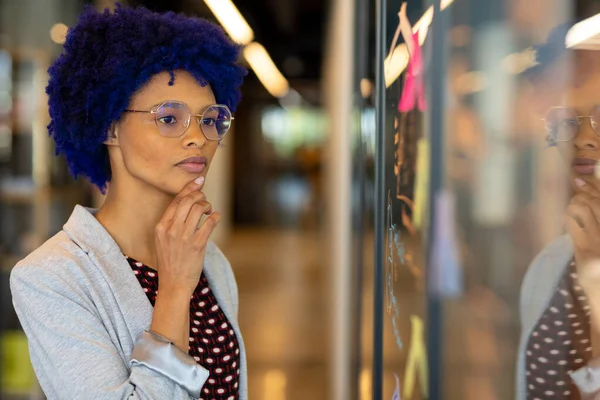 Thoughtful Biracial Casual Businesswoman Blue Afro Brainstorming Glass Wall Office — Stock Photo, Image