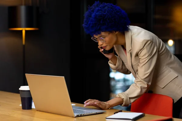 Biracial Casual Businesswoman Blue Afro Using Laptop Talking Smartphone Office — Stock Photo, Image