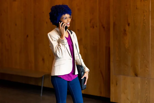 Happy Biracial Casual Businesswoman Blue Afro Talking Smartphone Office Corridor — Stock Photo, Image