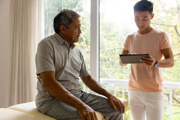 Diversi Fisioterapista Maschile Esaminando Paziente Anziano Sesso Maschile Utilizzando Tablet — Foto Stock