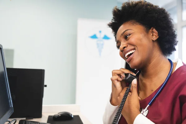 Önlük Steteskop Takıp Hastanede Telefonla Konuşan Mutlu Afro Amerikan Kadın — Stok fotoğraf