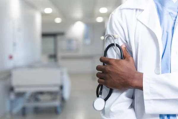 Middel Afrikansk Amerikansk Manlig Läkare Som Håller Stetoskop Korridoren Sjukhuset — Stockfoto
