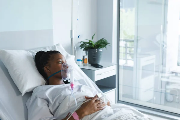 アフリカ系アメリカ人女性酸素マスク患者で 病院の部屋のベッドの上に横たわっている 変更なし — ストック写真
