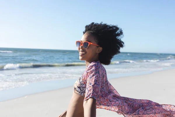 幸せなアフリカ系アメリカ人女性のサングラスを海で日当たりの良いビーチで笑みを浮かべて リラックスと休暇 変更なし — ストック写真