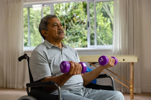 Paciente Masculino Biracial Sênior Determinado Cadeira Rodas Usando Halteres Fisioterapia — Fotografia de Stock