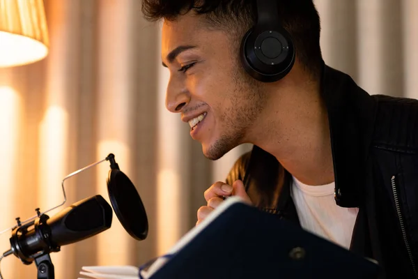 Ευτυχισμένος Διεμφυλικός Άντρας Ακουστικά Κρατώντας Σημειώσεις Και Μιλώντας Στο Μικρόφωνο — Φωτογραφία Αρχείου