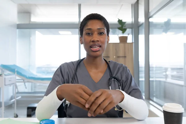 頭蓋骨と聴診器を身に着けているアフリカ系アメリカ人女性医師は 病院でビデオ通話をしています ビデオ通話 医療と仕事 変更なし — ストック写真