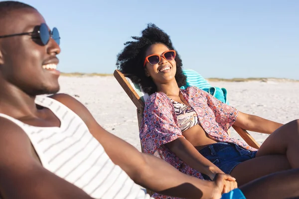 Feliz Casal Afro Americano Sentado Espreguiçadeiras Mãos Dadas Praia Ensolarada — Fotografia de Stock