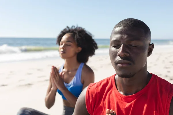 幸せにも 晴れたビーチに座ってヨガ瞑想を練習アフリカ系アメリカ人のカップルに適しています 健康的なライフスタイル リラックス 健康と休暇 変更なし — ストック写真