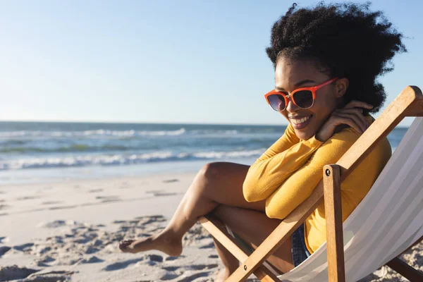 Portrait African American Woman Sunglasses Sitting Deckchair Smiling Sunny Beach — Stock Photo, Image