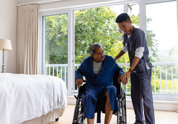 Diverse Male Doctor Helping Senior Male Patient Getting Wheelchair Home — Stock Photo, Image