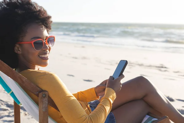 Portrait Happy African American Woman Sunglasses Sitting Using Smartphone Sunny — Stock Photo, Image