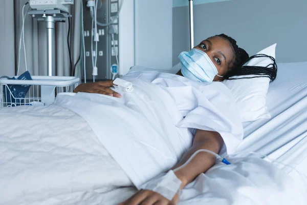 Afroamerykanka Pacjentka Masce Odwracając Wzrok Leżąca Łóżku Szpitalu Szpital Medycyna — Zdjęcie stockowe