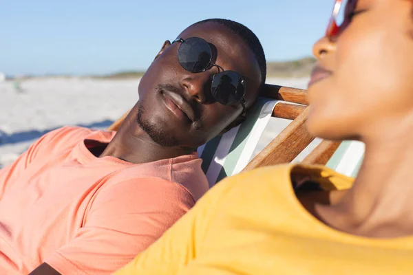 Happy African American Couple Sunglasses Sitting Deckchairs Relaxing Sunny Beach — Stock Photo, Image