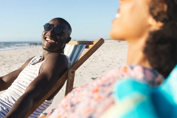 Happy African American Couple Sunglasses Sitting Deckchairs Laughing Sunny Beach — Stock Photo, Image