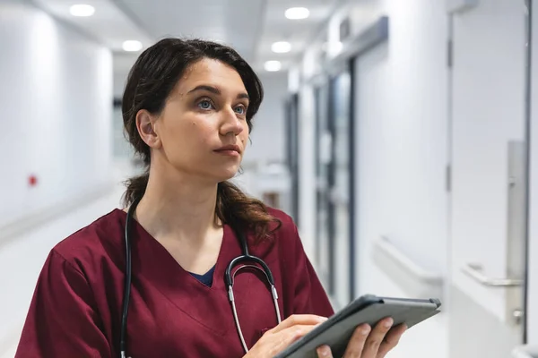 Kafkas Kadın Doktor Önlük Steteskop Giyiyor Hastanenin Koridorunda Tablet Kullanıyor — Stok fotoğraf