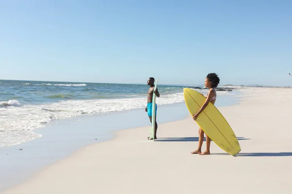 Afrykański Amerykanin Mężczyzna Kobieta Deskami Surfingowymi Stojący Słonecznej Plaży Patrząc — Zdjęcie stockowe