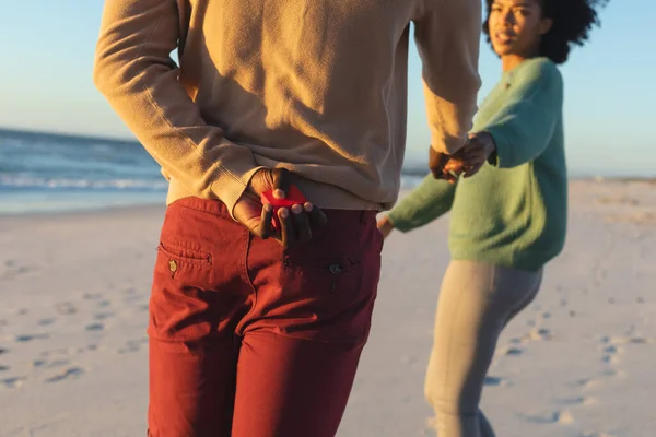 Africký Američan Drží Krabici Prstenem Žádá Přítelkyni Ruku Slunné Pláži — Stock fotografie