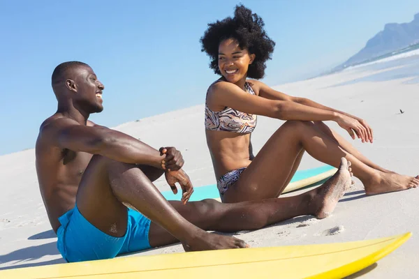 Šťastný Africký Americký Pár Sedí Slunné Pláži Surfy Mluvit Usmívat — Stock fotografie