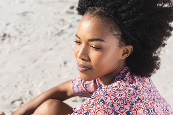 快乐的非洲裔美国女人微笑着 坐在阳光灿烂的海滩上 望着远方 放松和假期 — 图库照片