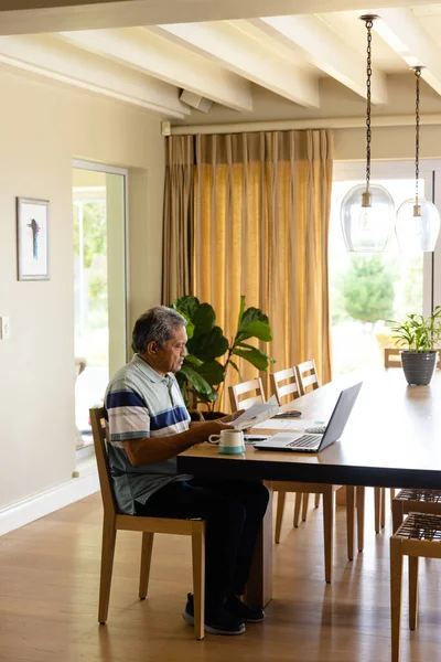 Biracial Senior Man Doing Paperwork Using Laptop Dining Room Finance — Stock Photo, Image