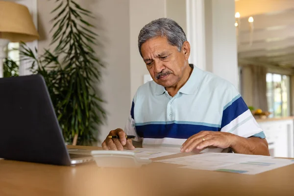 Hombre Birracial Mayor Haciendo Papeleo Usando Laptop Comedor Finanzas Jubilación —  Fotos de Stock