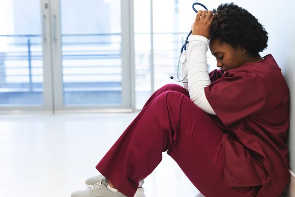 Müde Afrikanisch Amerikanische Ärztin Peelings Auf Dem Fußboden Krankenhausflur Sitzend — Stockfoto
