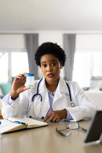 African American Female Doctor Holding Medication Making Video Call Bright — Stock Photo, Image