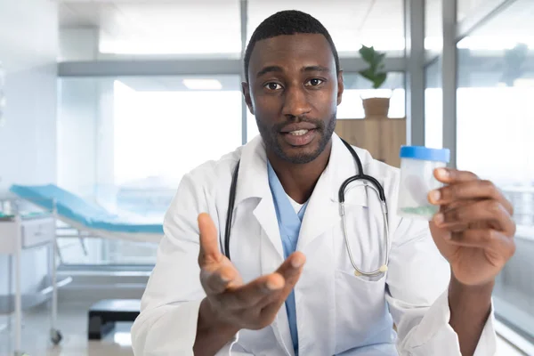 アフリカ系アメリカ人の男性医師は 研究室のコートと聴診器を着て 病院でビデオ通話をしています ビデオ通話 医療と仕事 変更なし — ストック写真