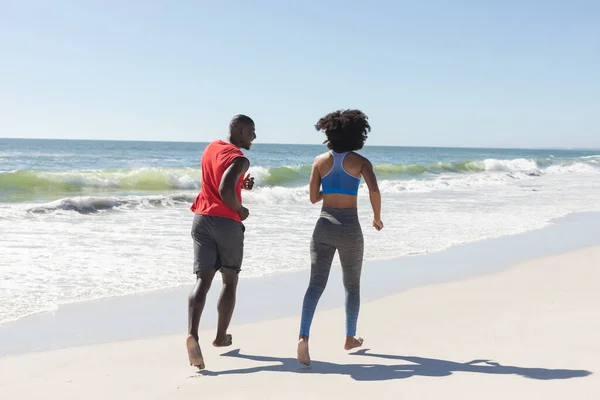幸せな アフリカ系アメリカ人のカップルの運動に適合し 日当たりの良いビーチで実行されます 健康的なライフスタイル フィットネス 自由な時間と休暇 変更なし — ストック写真