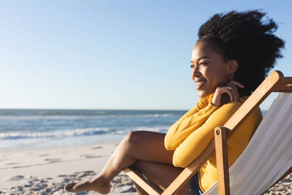 快乐的非洲裔美国女人坐在甲板上 微笑着坐在海上阳光灿烂的海滩上 闲暇时间和假期 — 图库照片