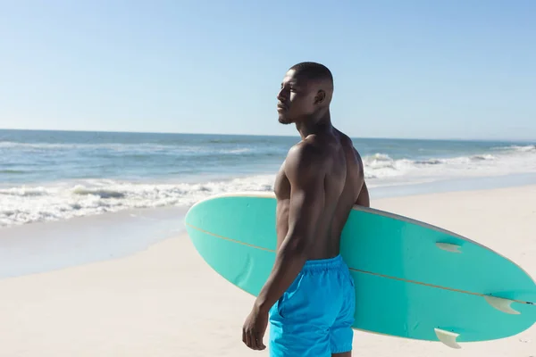 Ajuste Hombre Afroamericano Sosteniendo Tabla Surf Playa Soleada Mirando Hacia —  Fotos de Stock