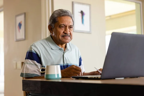 在餐厅里 一位年长的接生员正在做文书工作和使用笔记本电脑 家庭生活 通信和老年生活方式 — 图库照片