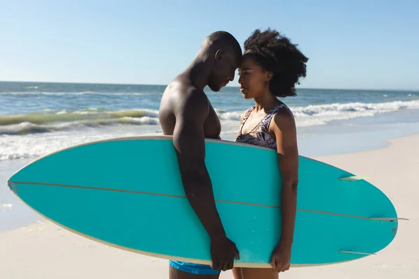 幸せなアフリカ系アメリカ人のカップルは 日当たりの良いビーチに触れる頭の上に立ってサーフボードを保持 ロマンス 健康的なライフスタイル スポーツ サーフィンや休暇 変更なし — ストック写真