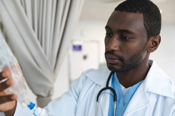 アフリカ系アメリカ人男性医師は 研究室のコートを着て 病院の部屋に点滴を適用します 医療と仕事 変更なし — ストック写真