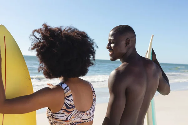 晴れたビーチで話して立ってサーフボードと幸せなアフリカ系アメリカ人のカップル 健康的なライフスタイル スポーツ サーフィンや休暇 変更なし — ストック写真
