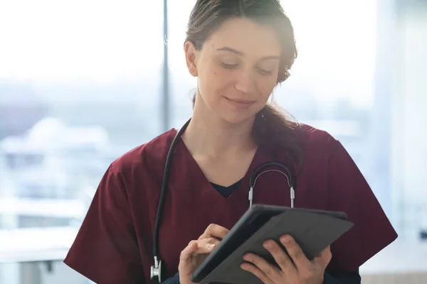 快乐的高加索女医生穿着洗涤剂和听诊器 在病房里使用平板电脑 保健和工作 — 图库照片