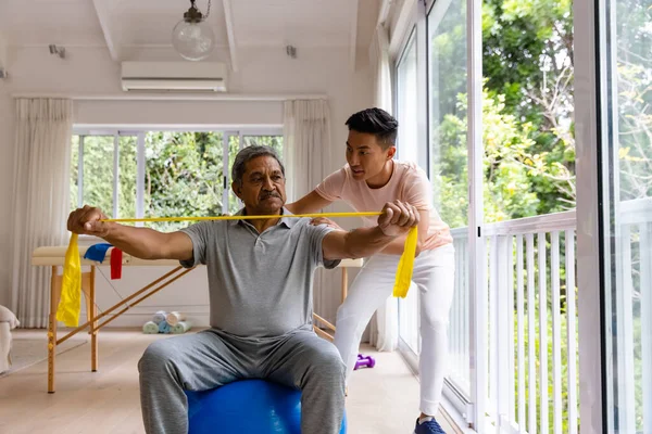 Çeşitli Erkek Fizyoterapistlerin Tavsiyeleri Egzersiz Bandı Kullanan Üst Düzey Erkek — Stok fotoğraf