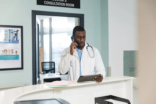 Médico Afroamericano Que Usa Tableta Habla Por Teléfono Inteligente Hospital — Foto de Stock