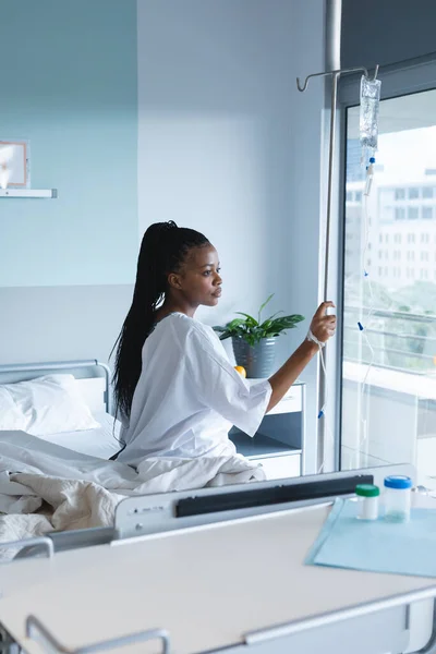 非洲裔美国女性病人坐在床上 在病房里滴水 医药和保健 未加改动 — 图库照片